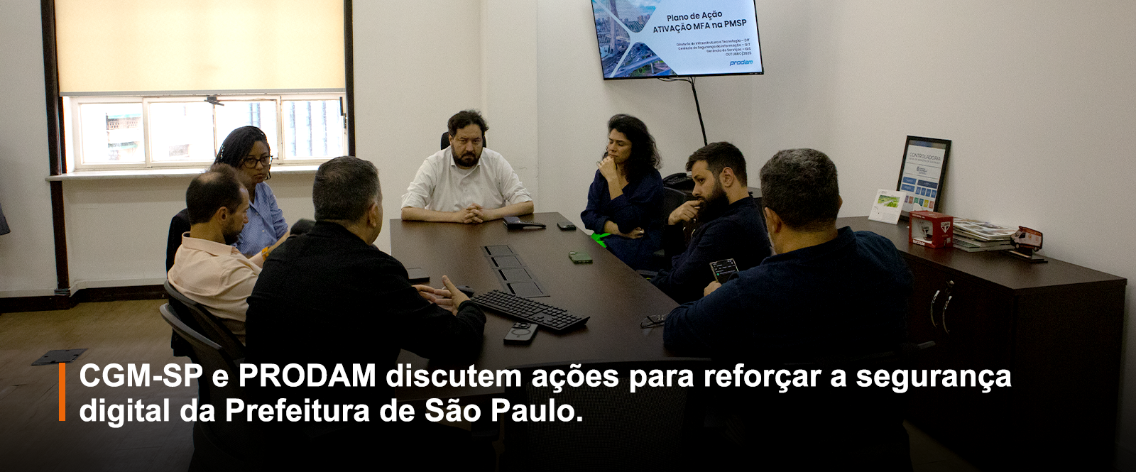 Imagem mostra servidores da CGM-SP e PRODAM numa sala de reunião