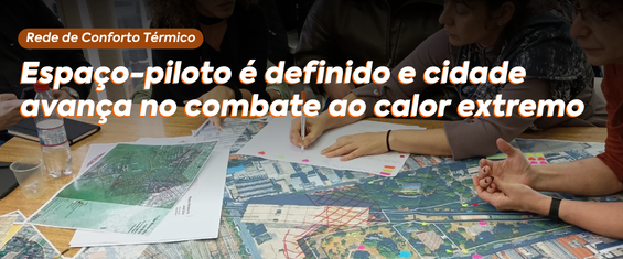 Foto de reunião de planejamento urbano. A imagem mostra um grupo de pessoas sentadas em torno de uma mesa coberta por grandes mapas e documentos. Alguns participantes apontam para os mapas enquanto outros fazem anotações em papéis, sugerindo uma discussão colaborativa. O ambiente transmite a ideia de encontro técnico voltado para planejamento ou questões ambientais. O texto presente na arte diz: “Rede de Conforto Térmico – Espaço-piloto é definido e cidade avança no combate ao calor extremo”. A composição reforça o caráter coletivo e estratégico da ação, destacando esforços voltados à adaptação climática e ao enfrentamento das altas temperaturas nas cidades.