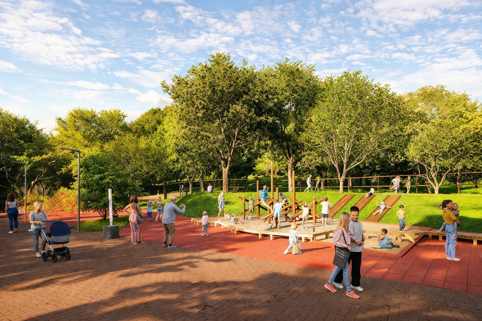 Esta fotografia colorida mostra uma movimentada área de lazer infantil em um parque ensolarado. Sobre um piso emborrachado terracota, crianças brincam em estruturas de madeira e rampas integradas à grama, cercadas por árvores verdes e uma árvore de flores rosas vibrantes. Adultos acompanham a cena, incluindo um homem próximo a um carrinho de bebê e casais caminhando. O ambiente é iluminado pela luz natural sob um céu azul com nuvens esparsas.